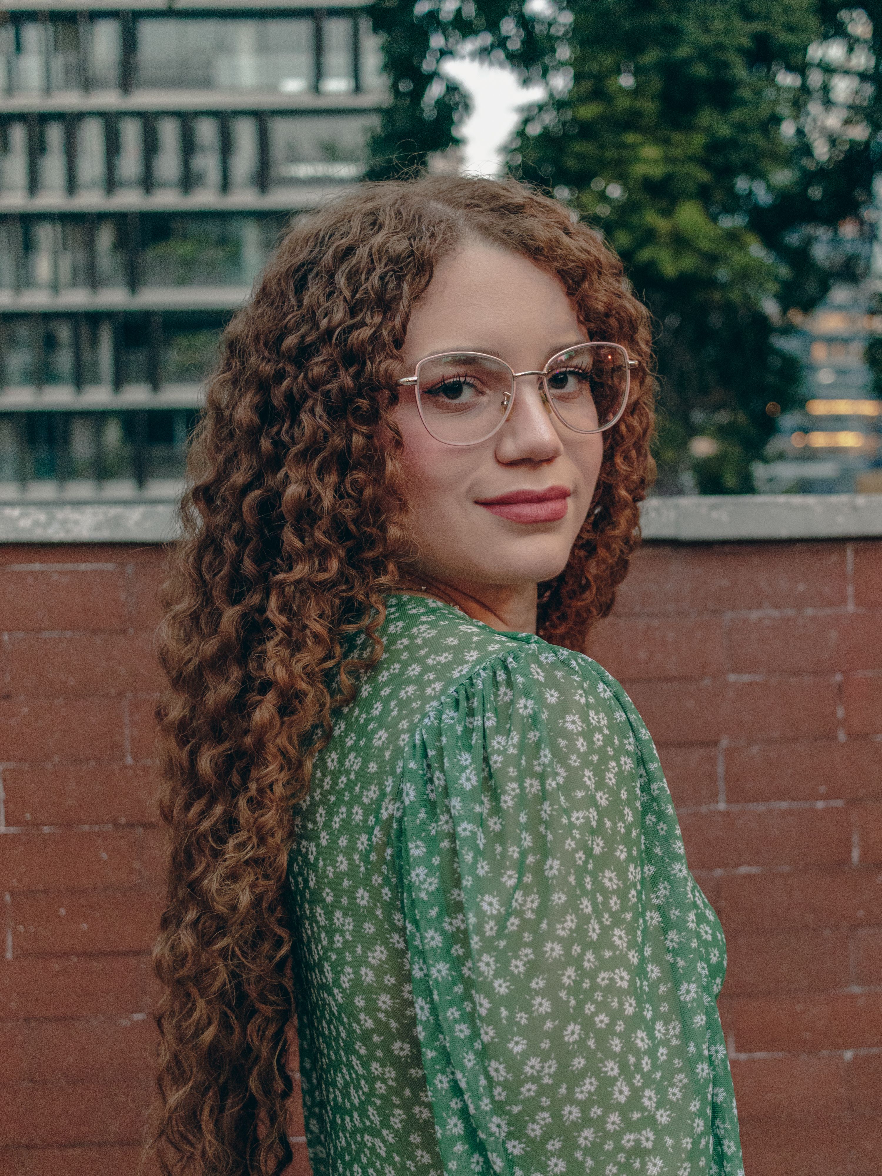 Portrait of a Woman with Curly Hair and Glasses · Free Stock Photo