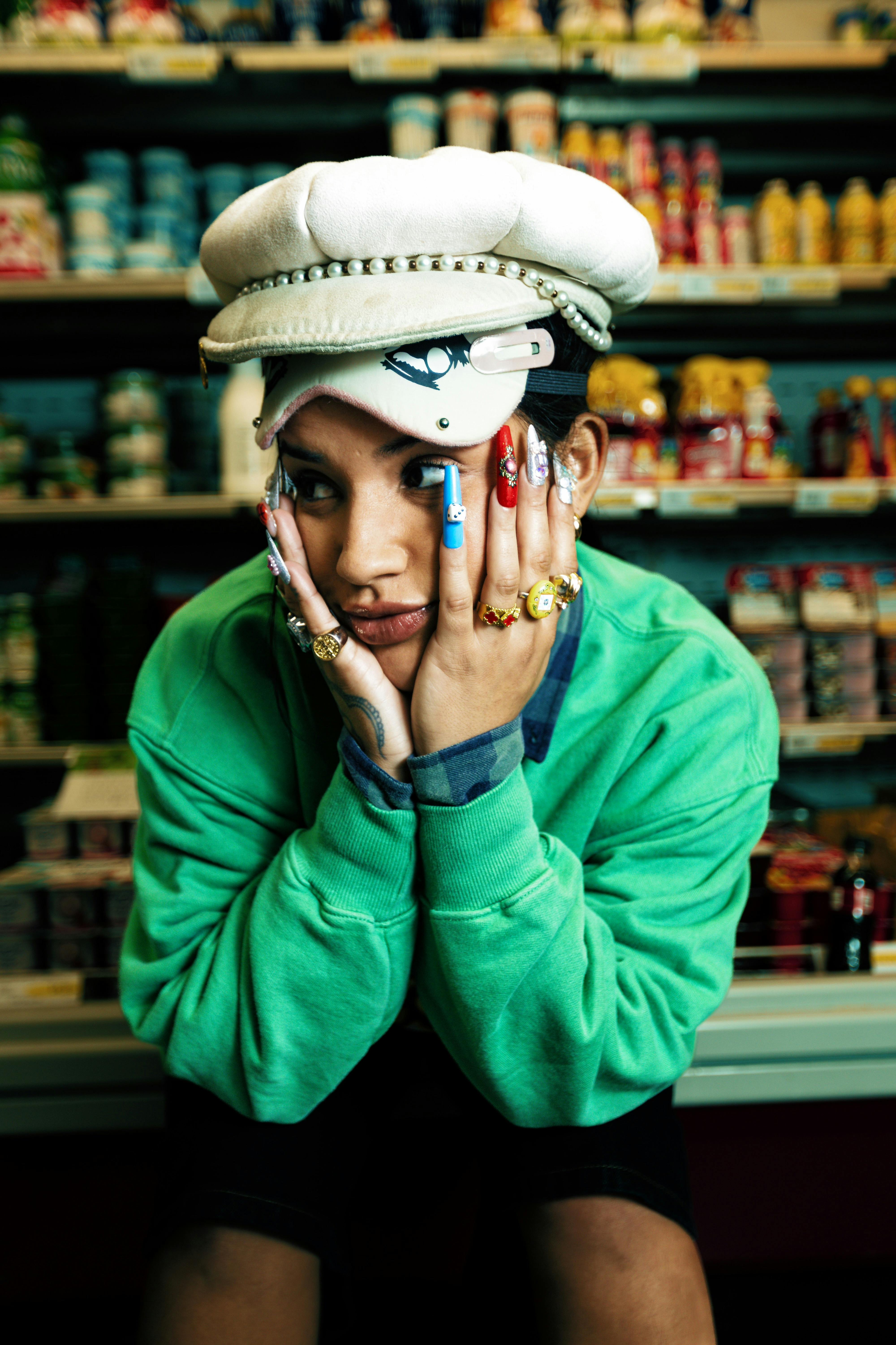 grátis Jovem em um supermercado com unhas e joias chamativas, exalando moda moderna. Foto profissional