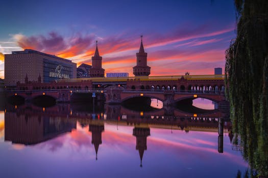 Captivating sunrise view of Oberbaum Bridge in Berlin with vivid reflections on the River Spree.