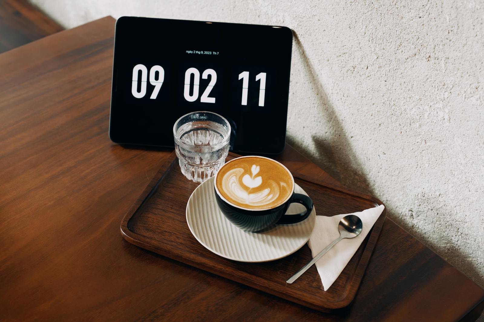 Steaming coffee cup beside a clock on a kitchen counter