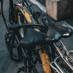 A black D-lock through a bike frame beside the saddle