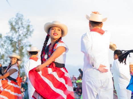 Colorful traditional dance performed outdoors in Oaxaca, Mexico, showcasing vibrant cultural attire.