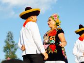A cultural scene of dancers in traditional Mexican attire during a festive event in Oaxaca, Mexico.