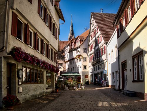 Free Quaint street in Calw, Germany with half-timbered buildings and vibrant flower displays. Stock Photo
