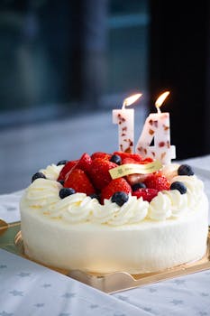 Elegant strawberry shortcake with candles celebrating a 14th birthday, ideal for festive occasions.