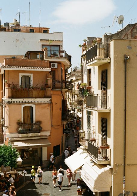 Vibrant street scene in Taormina, Sicily showcasing Italian architecture and lively atmosphere.