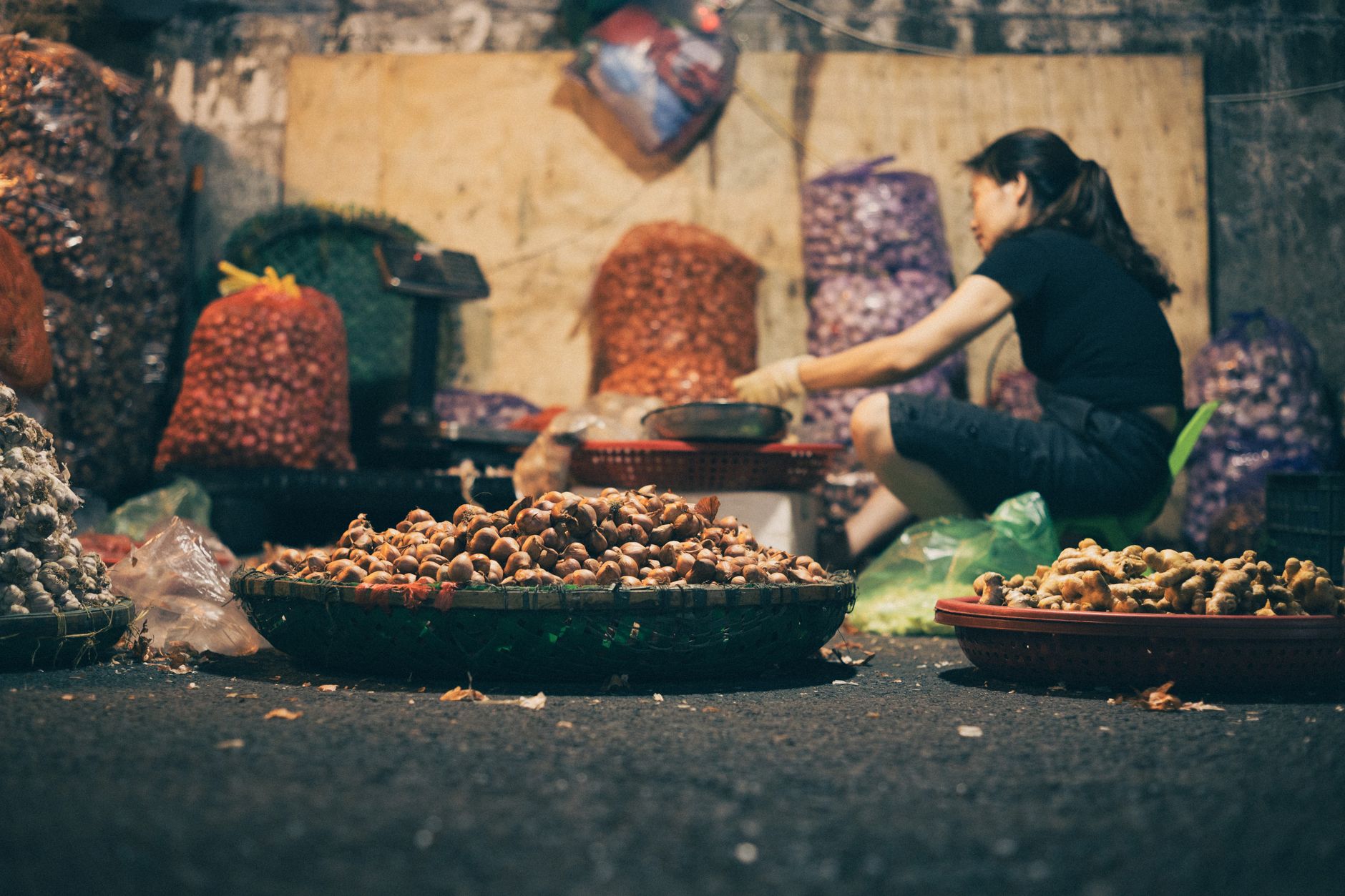 Captivating night market scene in Hanoi featuring a vendor with fresh produce, showcasing urban life's vibrancy.