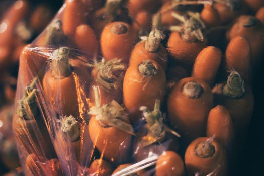 Fresh carrots wrapped in plastic, displayed at a Hanoi night market.