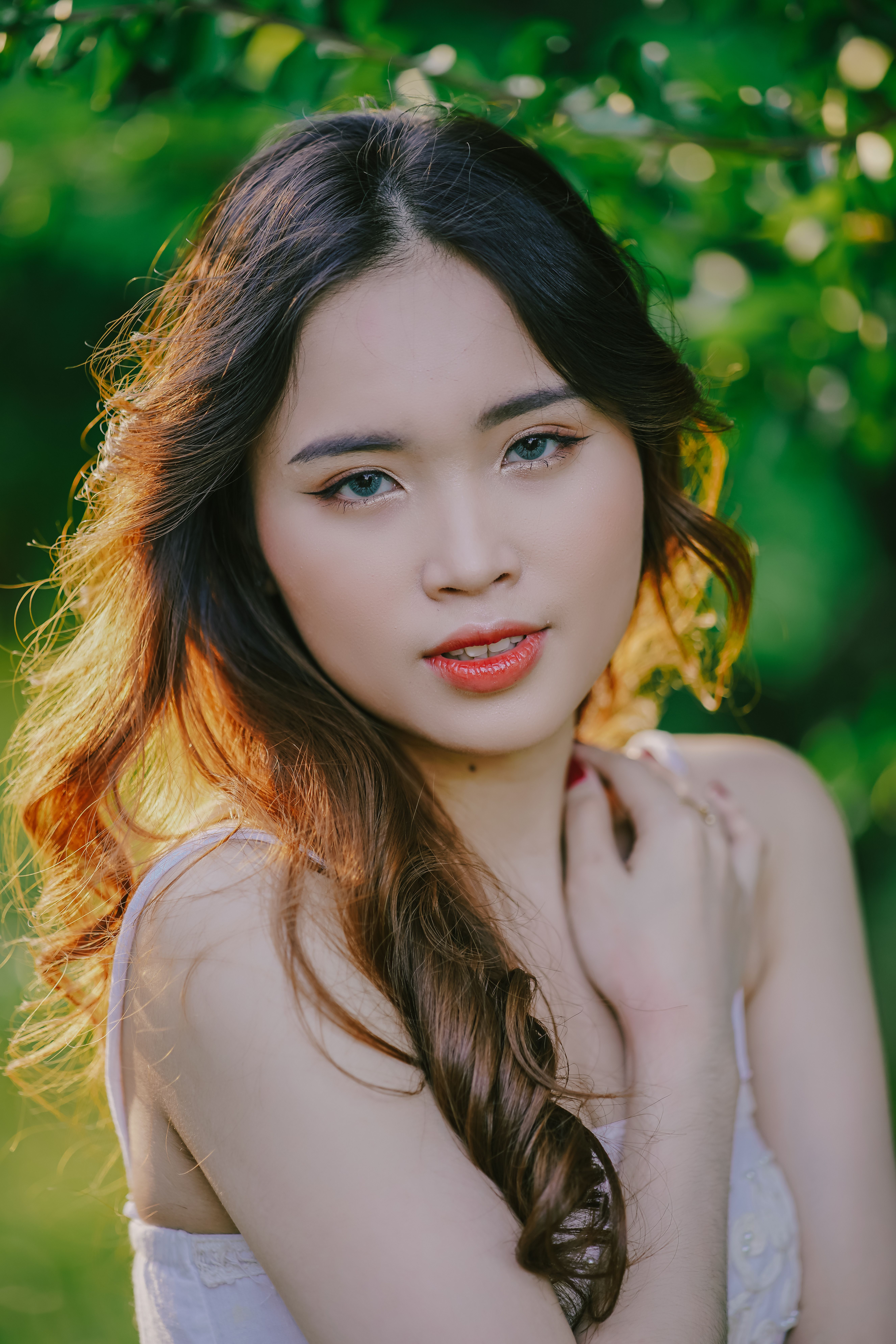 Elegant portrait of a young woman with natural beauty, surrounded by lush greenery.