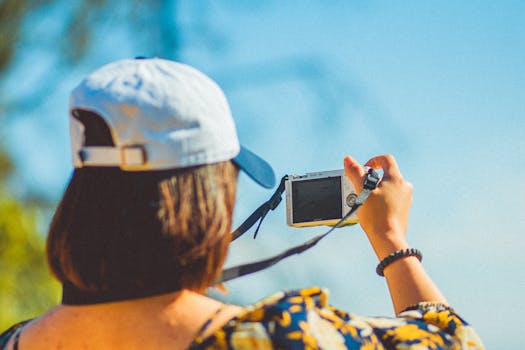 Woman in a cap taking outdoor photos with DSLR. Sunny day vibes.