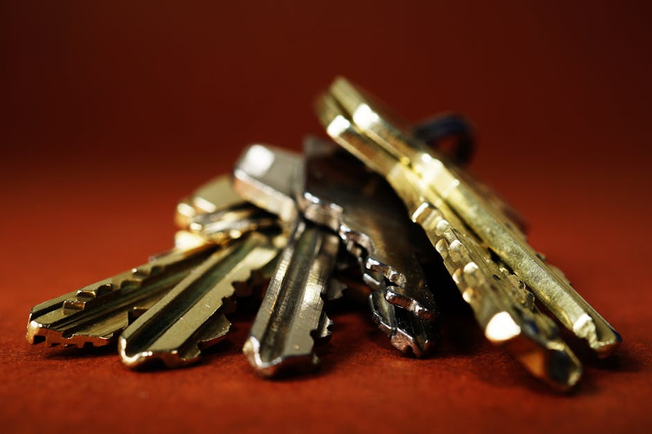 Detailed view of a pile of metallic keys on a deep red surface, emphasizing security and safety.