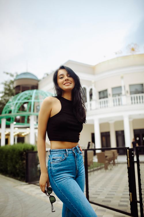 Free Stylish young woman in a black top and jeans posing outdoors in Tbilisi, Georgia, showcasing natural beauty and fashion. Stock Photo