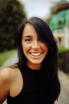Vibrant portrait of a smiling woman outdoors in natural light.