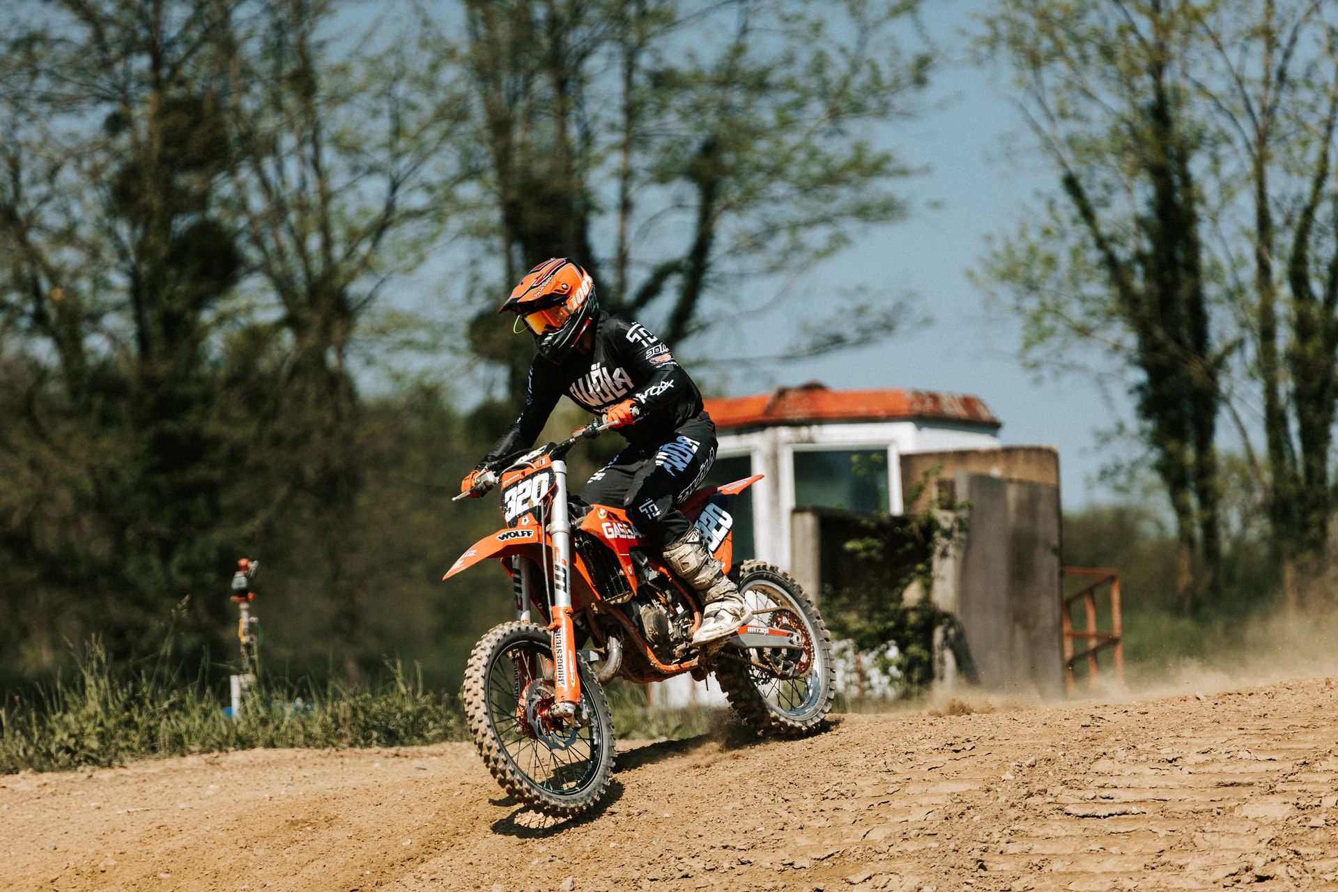 Exciting motocross race capturing rider on dirt track in outdoor setting.