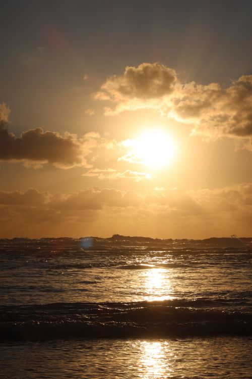 Free Sunset over the ocean at Lacanau, France. Warm hues and clouds create a stunning seaside view. Stock Photo