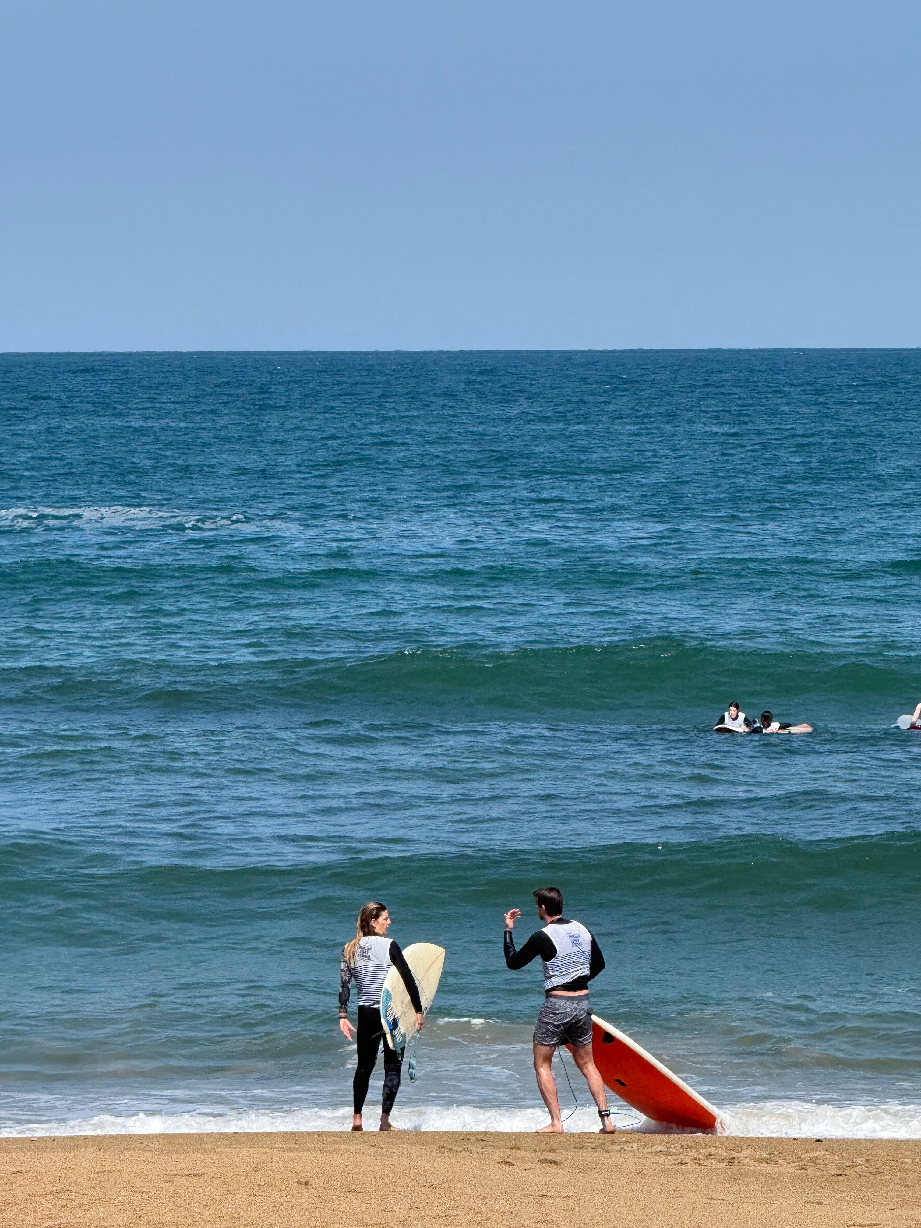 Surfers preparing on the sand used to illustrate Barefoot Surf School at Putsborough Sands