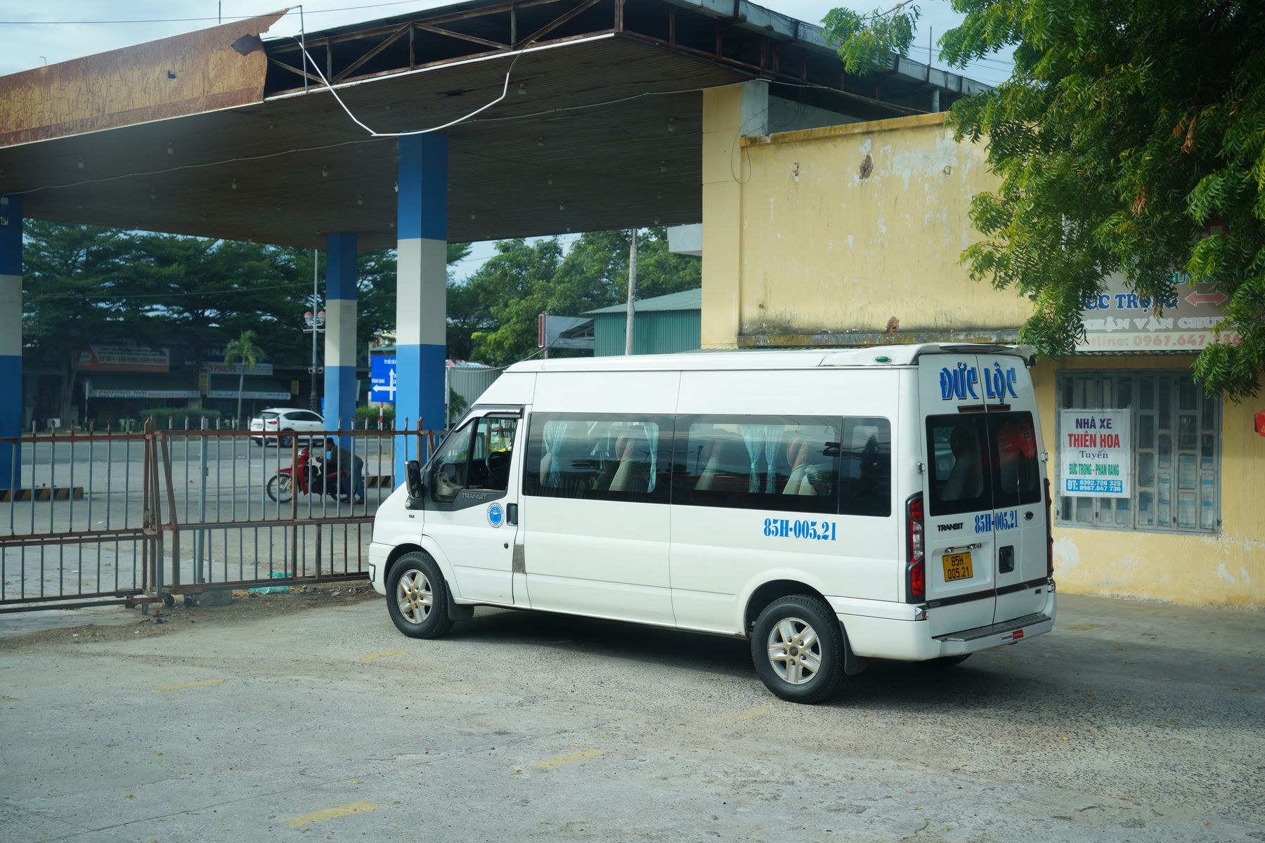 Minibús blanco estacionado bajo la cubierta de una terminal