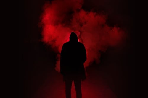 男子站在黑色和紅色背景下的剪影