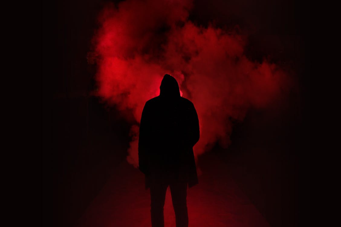 免费 男子站在黑色和红色背景下的剪影 素材图片