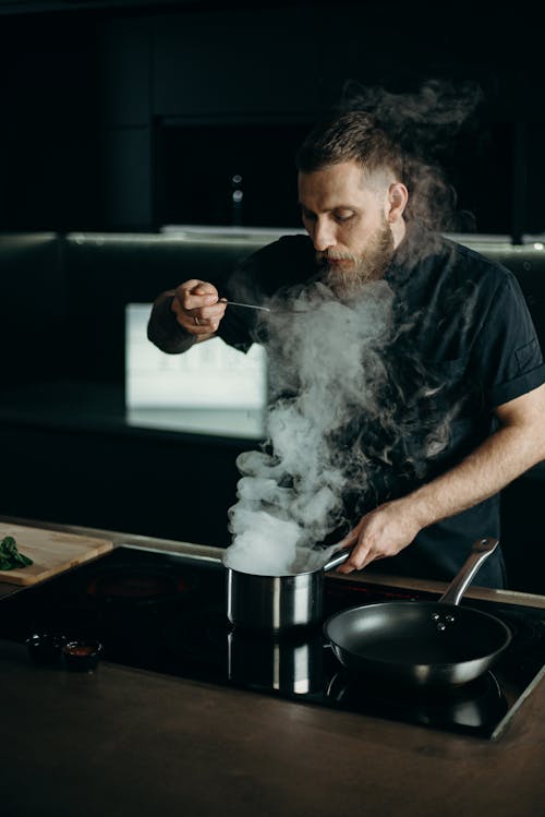 Free Man Tasting What He Is Cooking Stock Photo