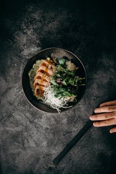 这是一道美味的亚洲菜肴，表面呈深色纹理，搭配新鲜沙拉和筷子