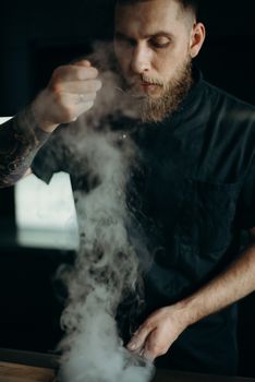 在光线昏暗的厨房里，一位厨师仔细品尝着热气腾腾的菜肴，捕捉烹饪的艺术