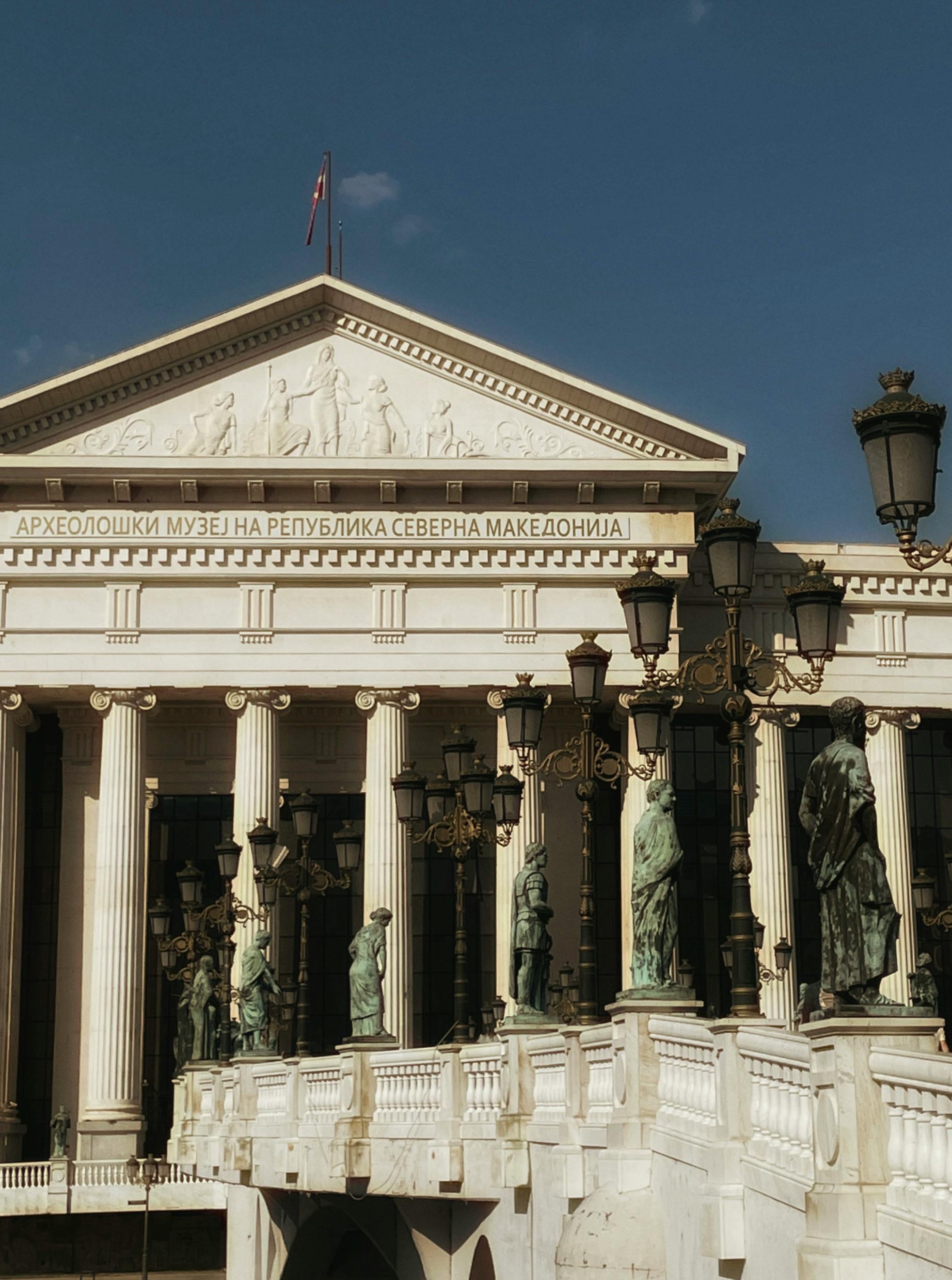 Exterior view of the Archaeological Museum in Skopje, showcasing classic architecture and statues.