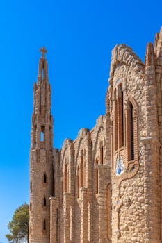 Stunning architecture of Santuario de Santa María Magdalena in Novelda, Spain against a clear blue sky.