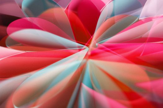 Vivid abstract light pattern of red, blue, and pink hues creating a floral shape.