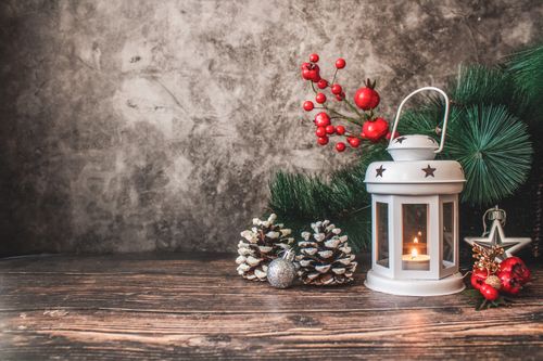 Free A charming festive arrangement featuring a glowing lantern, pinecones, and Christmas ornaments. Stock Photo