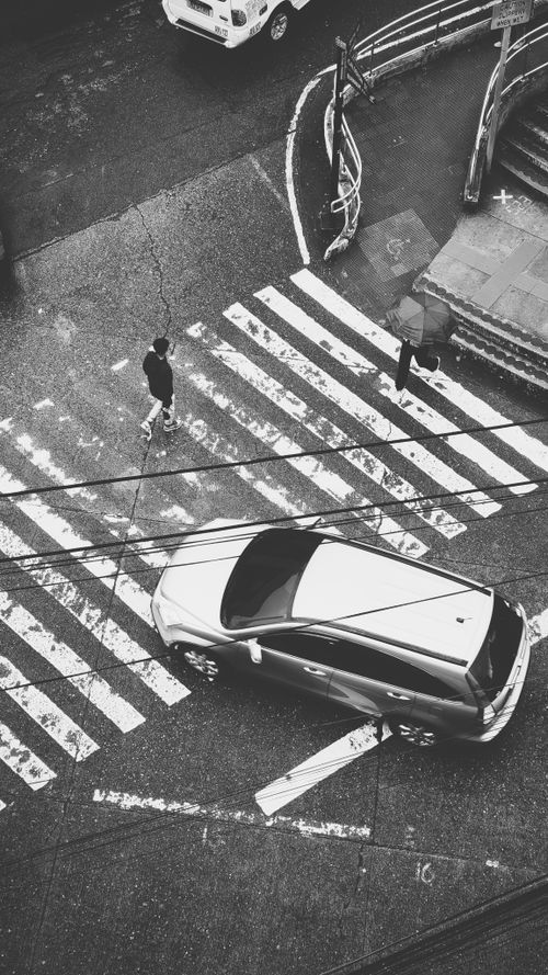 Free Black and white aerial shot of pedestrians crossing a city road in Baguio, Philippines. Stock Photo