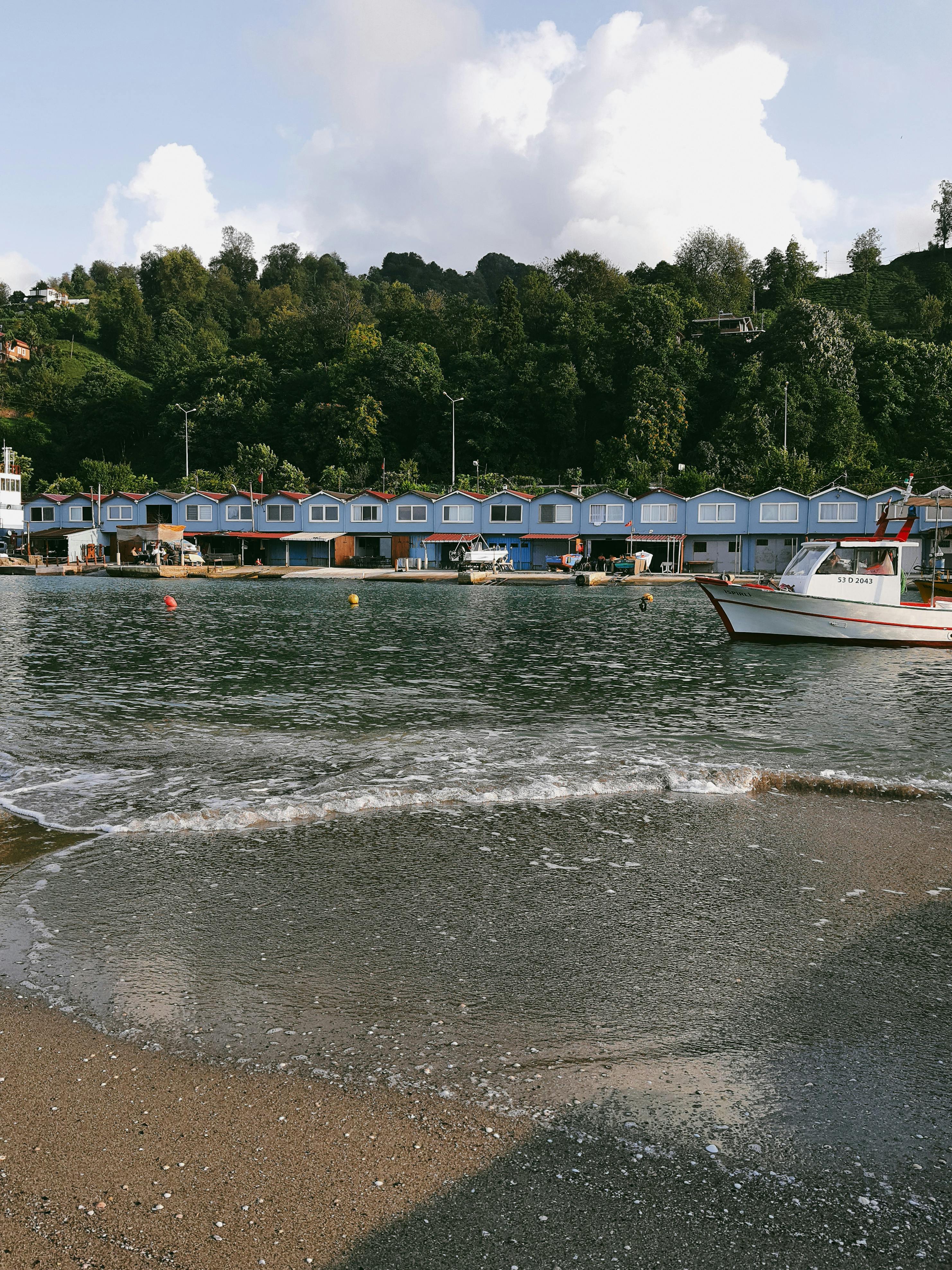 Serene view of Derepazarı's shoreline in Türkiye, highlighting colorful buildings and calm waters.