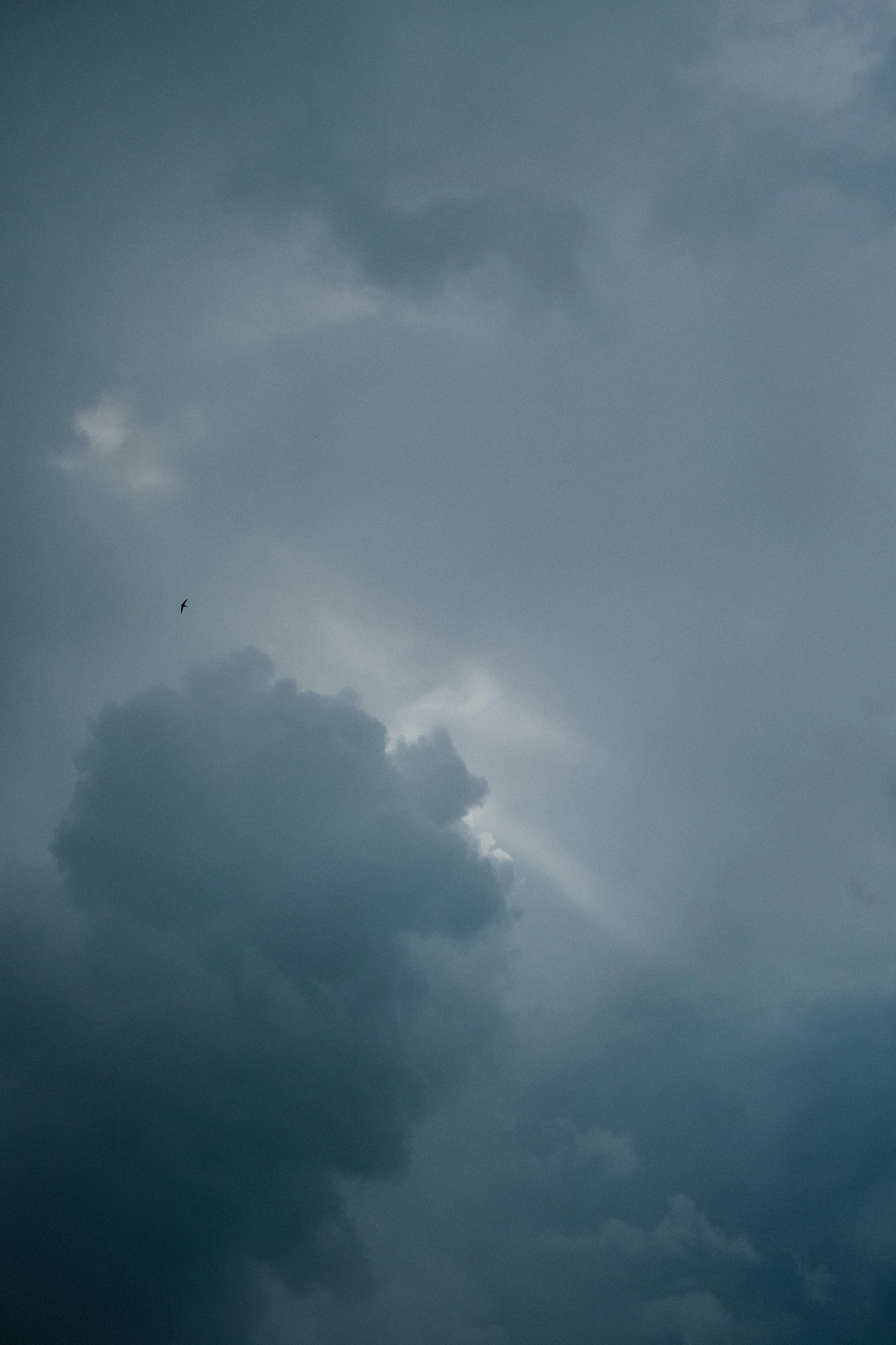 Free Dramatic cloudy sky with sunlight peeking through, creating a moody atmosphere. Stock Photo
