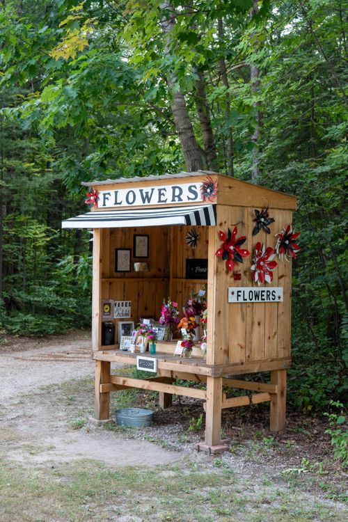 Free Charming wooden flower stand nestled in the woods offering fresh bouquets in Michigan. Stock Photo