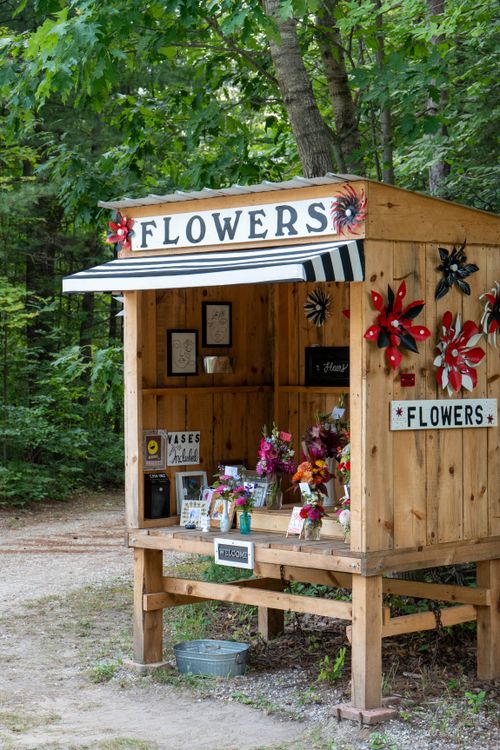 Free A quaint flower stand showcasing vibrant summer blooms in Manistee, Michigan's scenic woods. Stock Photo