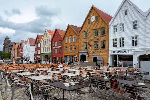 Colorful wooden buildings and outdoor cafes at Bryggen Wharf, Bergen, Norway.