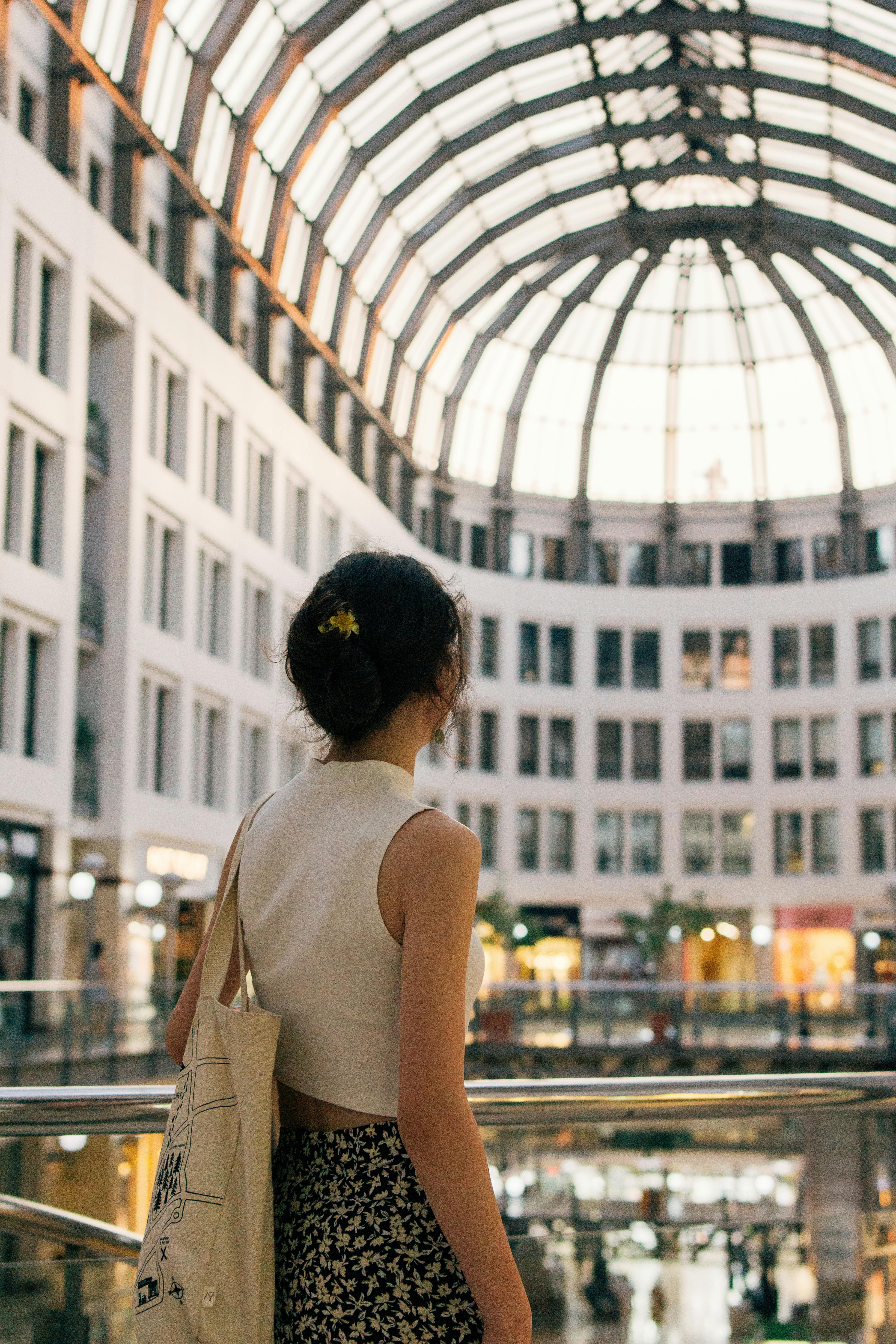 A young woman gazes at the futuristic architecture of an Ankara shopping mall, Türkiye.