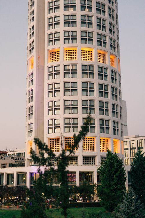 Free A modern cylindrical building in Ankara, Türkiye, captured at dusk with warm lights glowing through windows. Stock Photo