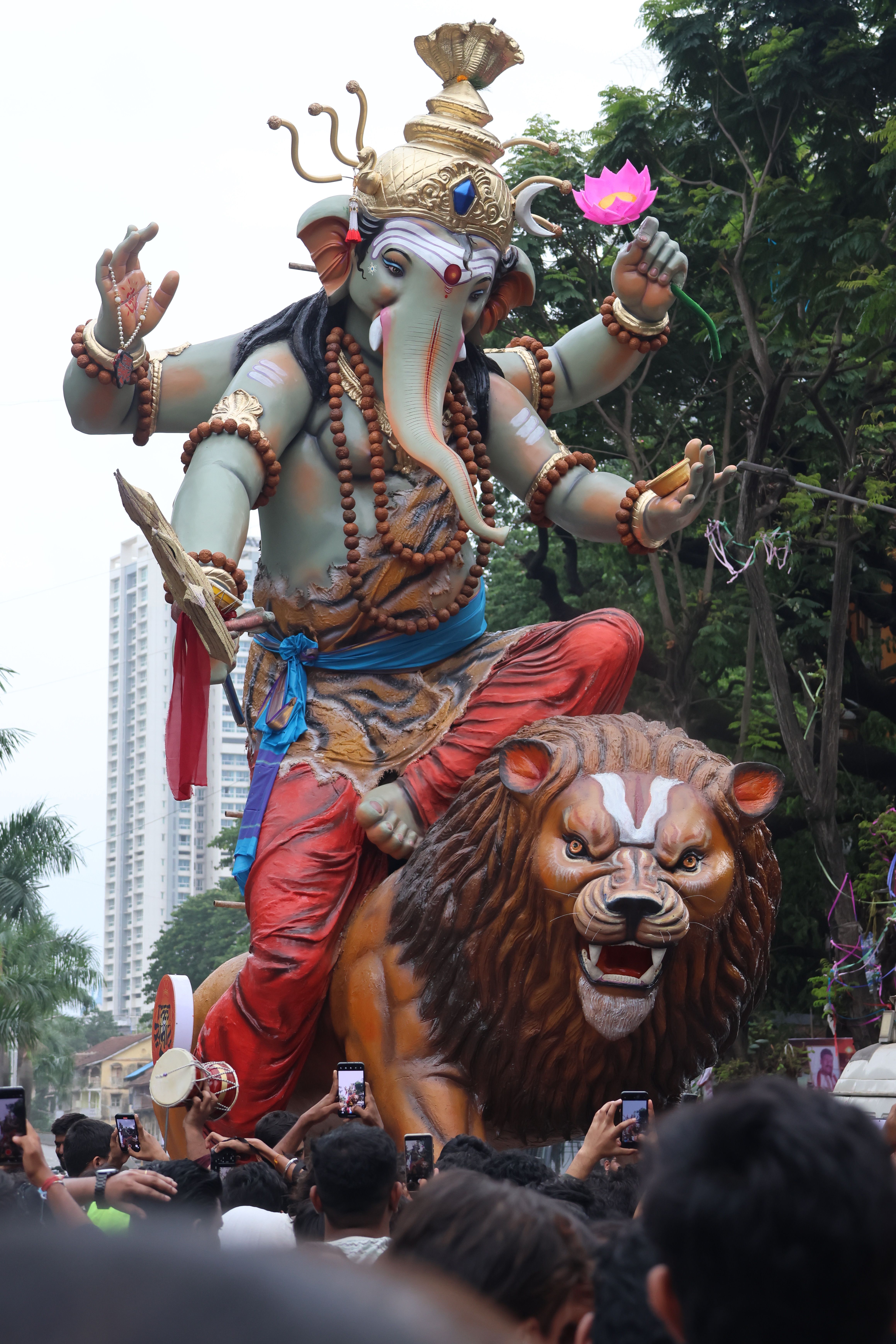 Large Ganesha statue displayed during a vibrant Indian festival outdoors.