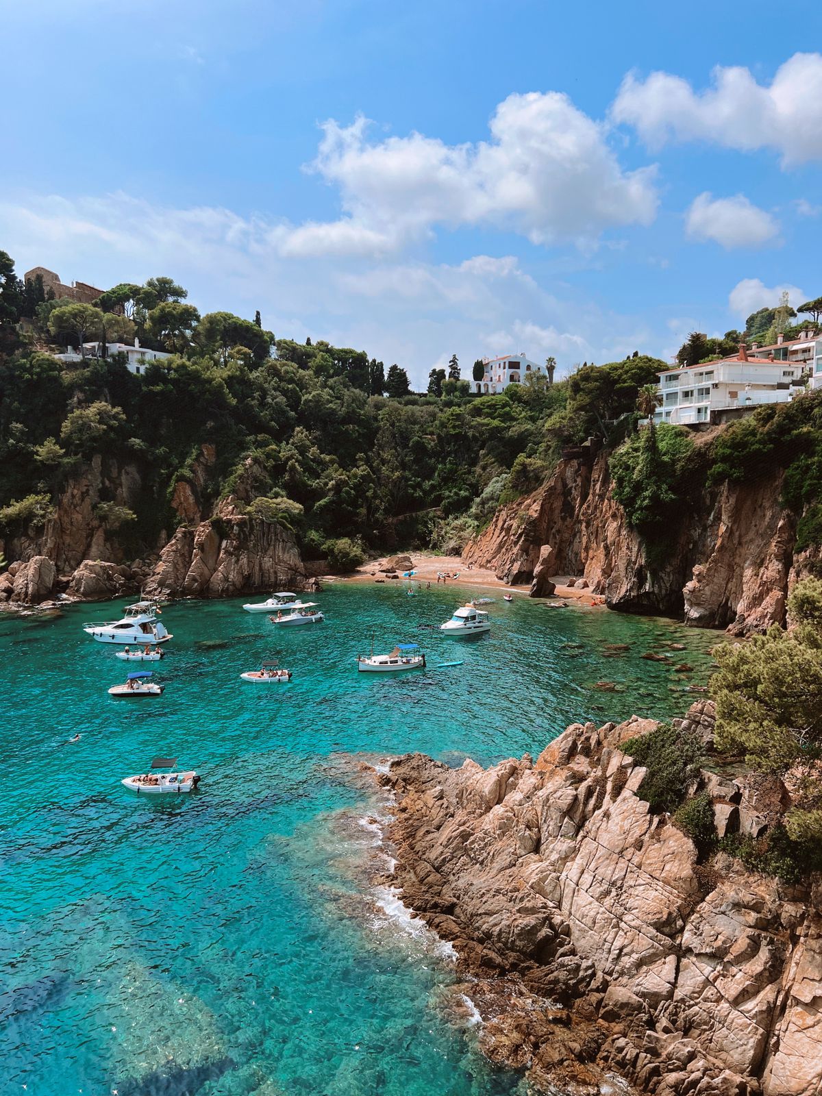 Cala Sa Boadella lângă Lloret de Mar cu apă limpede și bărci