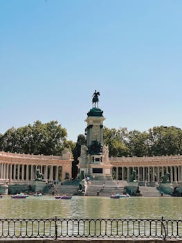 Scenic view of Alfonso XII monument with boating lake in Retiro Park, Madrid.