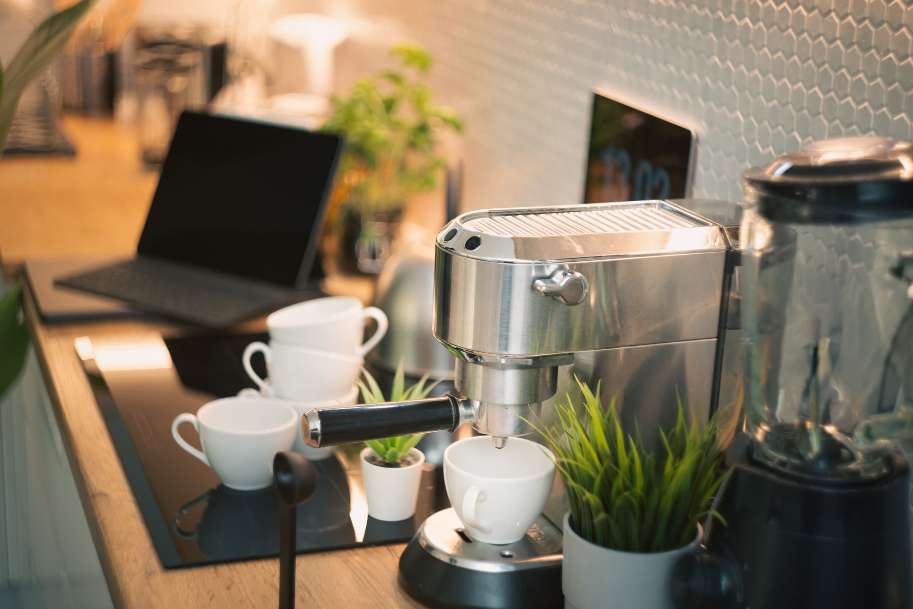 Shared apartment command center idea: compact counter with laptop, mail tray, plant, and coffee maker by the kitchen.