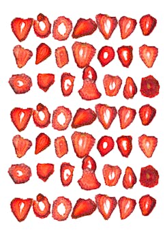 Vibrant dried strawberry slices arranged on a white backdrop for culinary creativity.