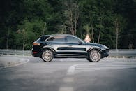 Sleek Black SUV on a Serene Forest Road