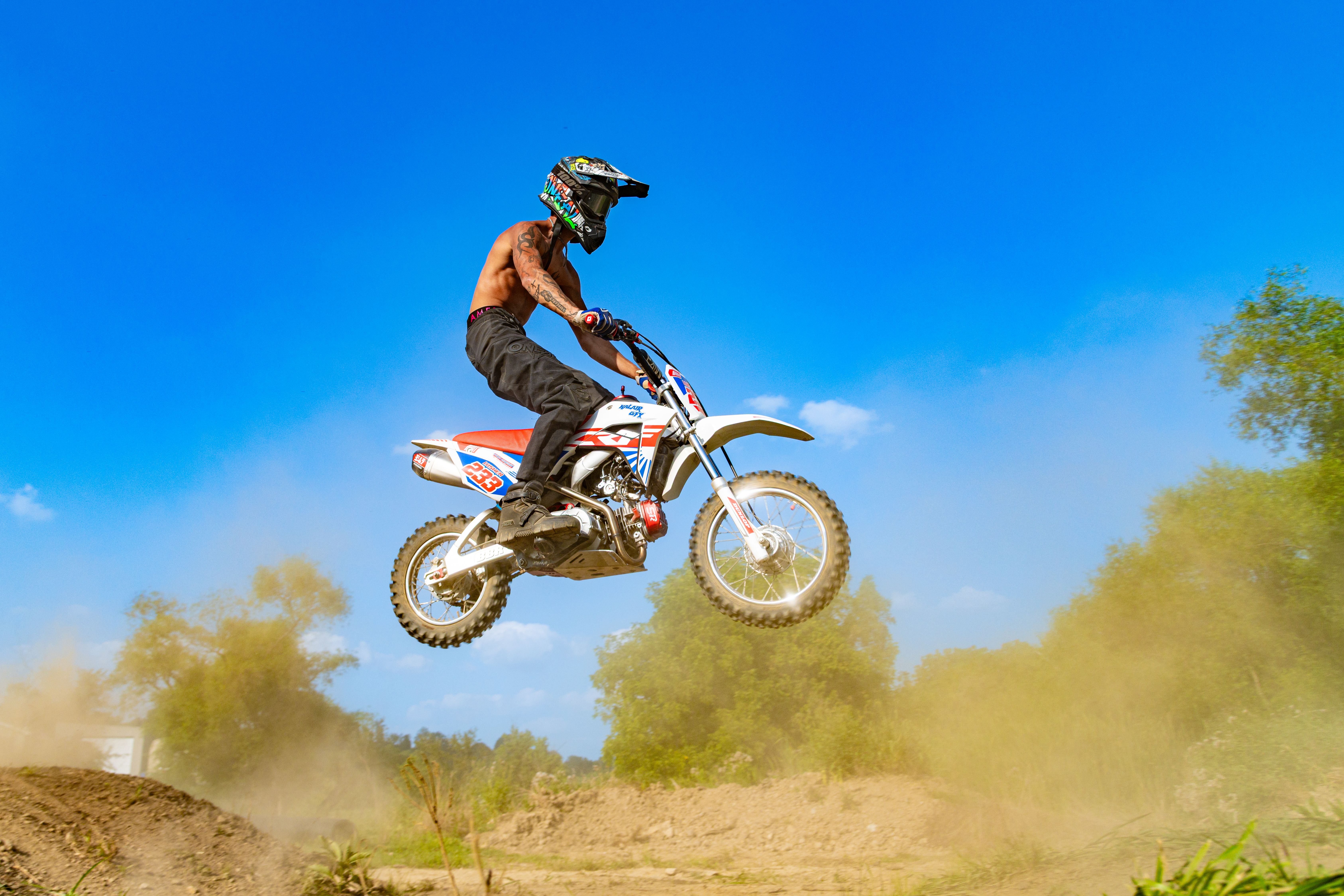Rider performs an exciting jump on a dirt bike at an outdoor motocross track.