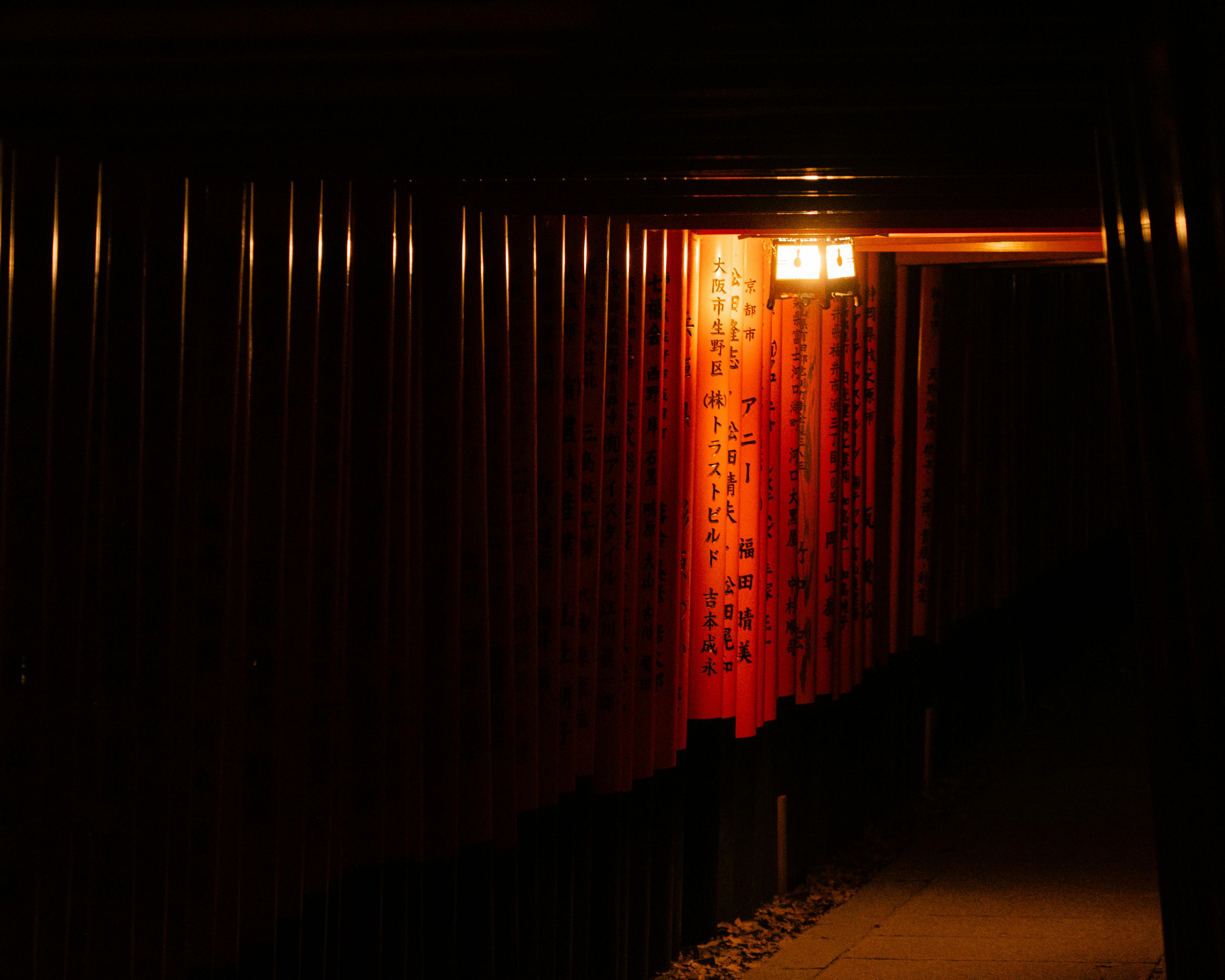 Free Illuminated torii gates at Fushimi Inari Taisha in Kyoto captured at night, evoking a sense of serenity and ancient tradition. Stock Photo