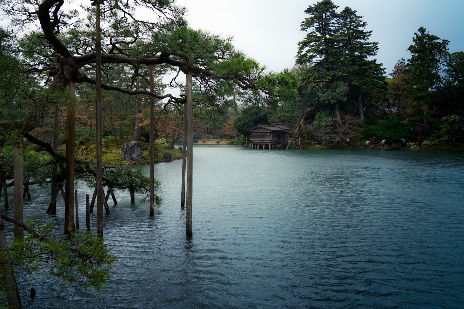 A tranquil view of a Japanese garden in Tokushima with a serene lake and lush greenery.