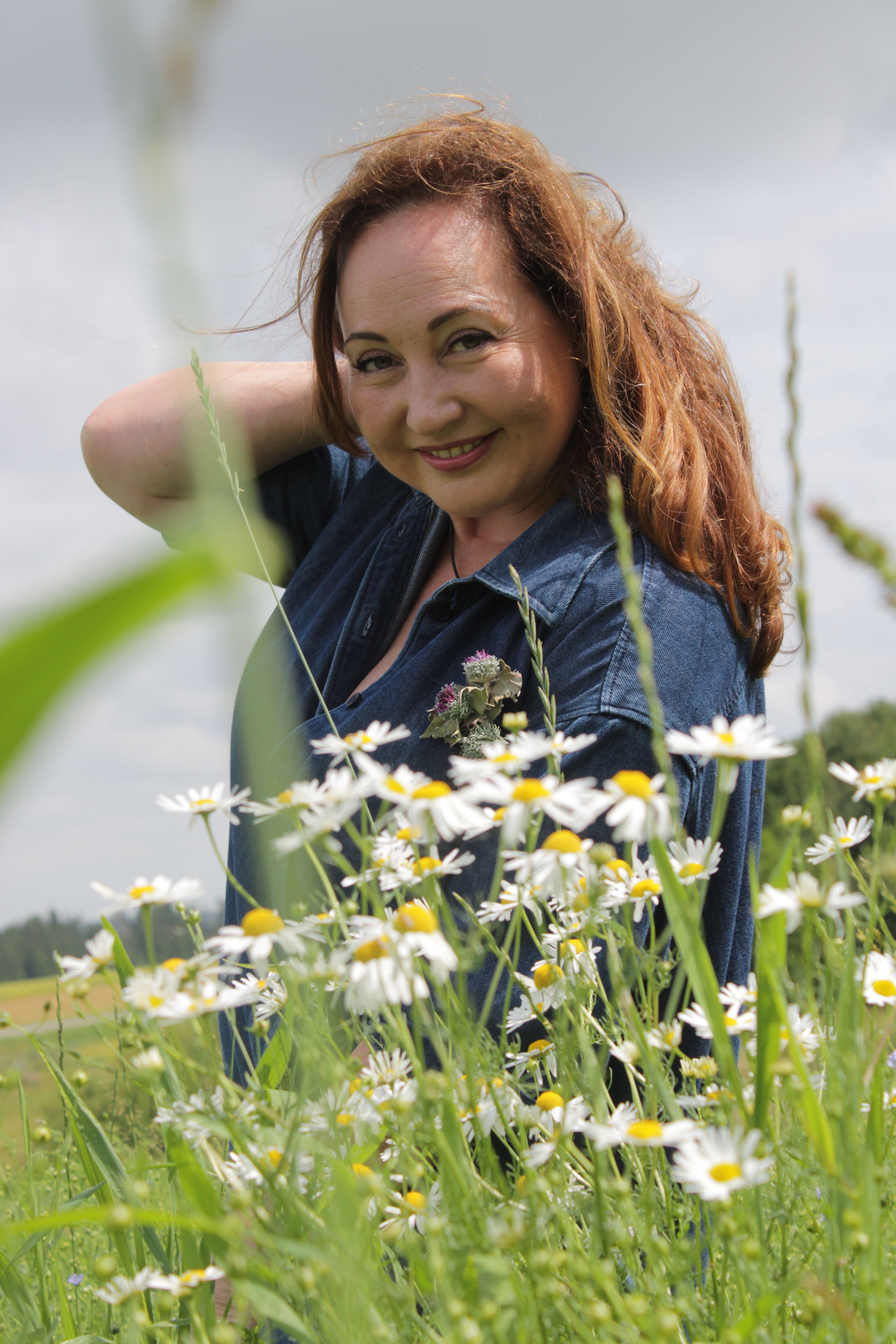 Joyful woman enjoying the outdoors in a field of daisies.