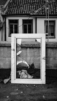 A broken window frame rests on a rooftop in Bursa, Türkiye, offering a moody black and white view.