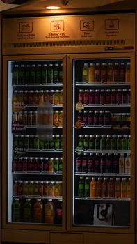 Vibrant display of various juice bottles in a refrigerated cooler at a Jakarta store.